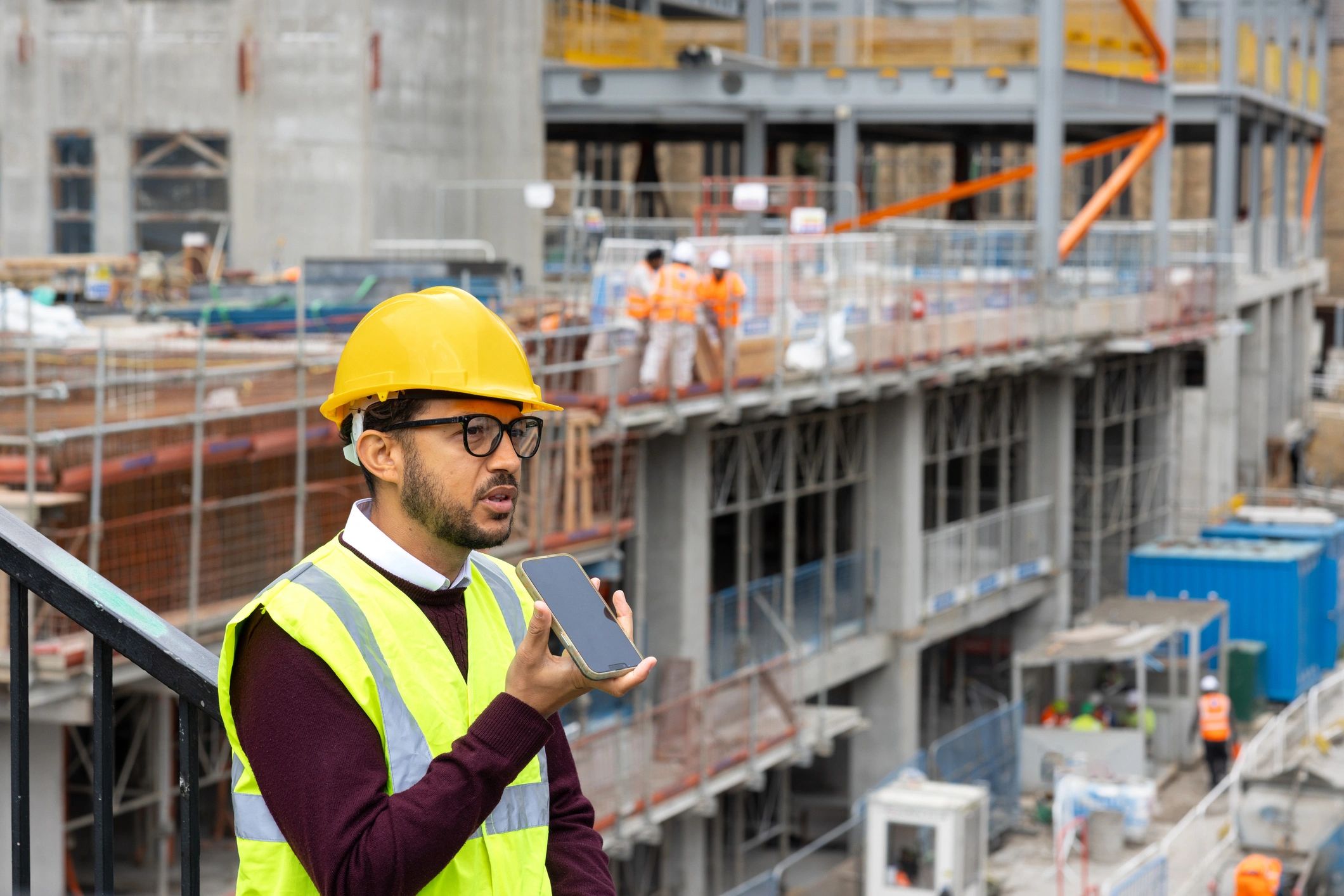 Contractor in a hard hat reviewing a job site while on the phone